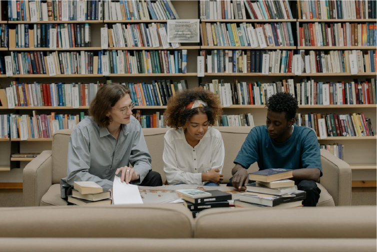 Grupo de estudiantes estudiando en una biblioteca.