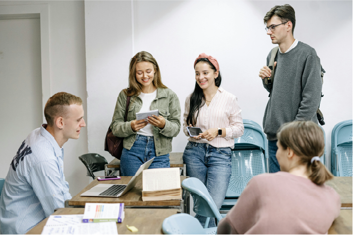 Grupo de estudiantes en un salón compartiendo ideas y dialogando.